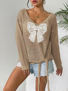 Detail von hohlem Strickpullover mit großer weißer Spitzenschleife und V-Ausschnitt
