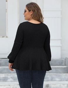 Back view of black long sleeve peplum top showing ribbed texture and ruffled waist design