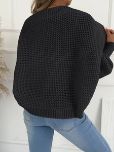 Details der schwarzen Waffelstrick-Textur und Rippbündchen an einem Damenpullover