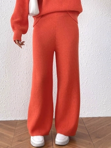 Detailed texture of vibrant orange ribbed knit high waist wide leg trousers for women