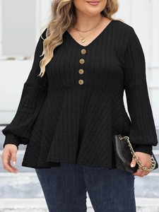 Detail showing V-neckline with decorative gold buttons and ribbed knit texture on a black top