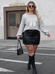 Detail of grey plus size ribbed knit sweater with large white lace bow embroidery