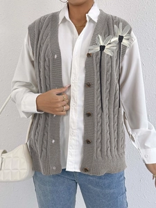 Women's gray cable knit vest with 3D floral accents and buttons over a white shirt