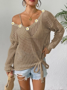Detail of khaki crochet knit top with V-neck daisy flowers and waist tie styling