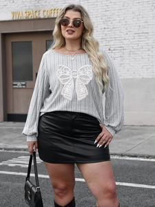 Plus size gray knit top with white lace bow detail and black faux leather skirt