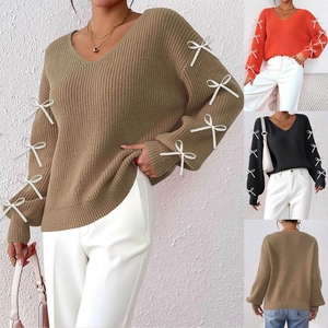 Detail of V-neck knit sweater with 3D white ribbon bows on sleeves in khaki and orange