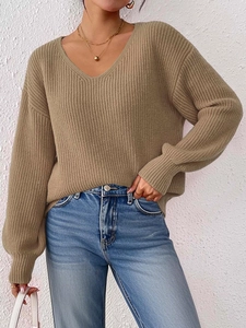 Dettaglio ravvicinato del maglione in maglia kaki con scollo a V e trama a coste verticali