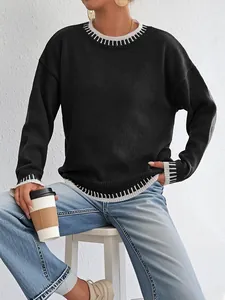 Dettaglio della maglia a coste a contrasto e delle cuciture su un maglione nero oversize