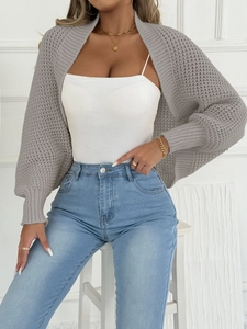 Lässiger grauer Strick-Bolero für Damen mit weißem Top und blauer Jeans kombiniert