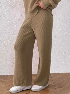 Detail of khaki ribbed knit wide-leg trousers showing fabric texture and elastic waist