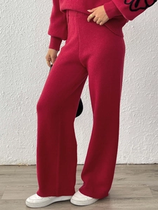 Detailed knit texture of red wide-leg trousers and sleeve with floral pattern