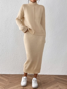 Détail de l'ensemble en maille beige montrant le pull à col montant et la jupe midi