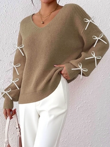 Close-up of khaki V-neck knit sweater featuring elegant white satin bow details on sleeves