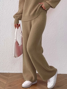 Detail view of khaki knitted wide-leg trousers showing vertical ribbed texture and drape