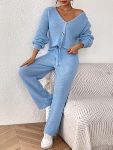 Detail of light blue knit set featuring amber buttons and ribbed cuffs on the cardigan