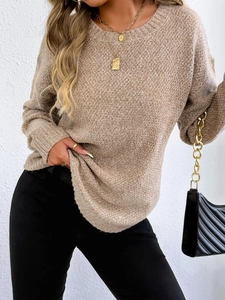 Detail of khaki crewneck sweater featuring chunky knit texture and gold chain bag accessory