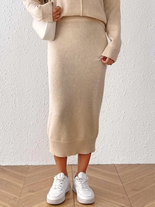 Detail of knitted oatmeal midi skirt and sweater set with a textured ribbed finish