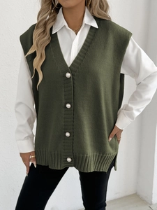 Détail du gilet tricoté vert olive avec gros boutons perles et fente latérale côtelée