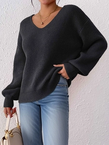 Dettaglio maglione in maglia con scollo a V, trama a coste e design a spalle scese morbido