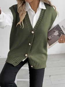 Gilet en tricot vert foncé avec col en V et boutons en perles sur chemise blanche