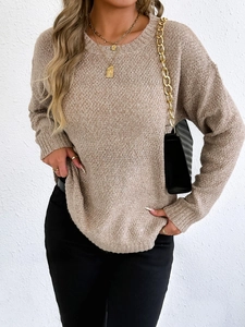 Close-up of beige knit sweater showing the soft marled texture and ribbed round neck