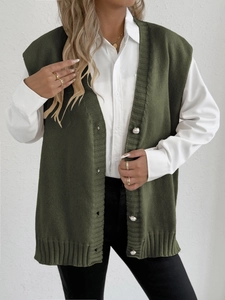 Détail du gilet tricoté vert foncé avec boutons perlés et texture côtelée verticale