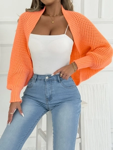 Nahaufnahme des leuchtend orangen Grobstrick-Boleros mit gerippten Bündchen und Ärmeln