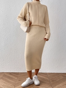 Détail d'un élégant ensemble en maille beige avec pull et jupe mi-longue à côtes