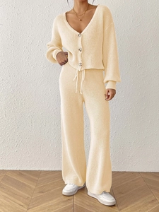 Detailed knit texture of a cream V-neck cardigan and matching drawstring trousers set