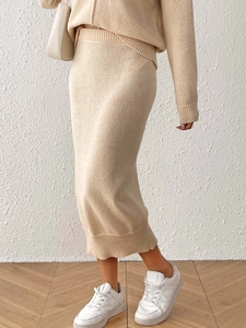 Detail of knitted beige long sleeve top and midi skirt set with soft ribbed texture