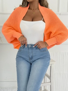 Nahaufnahme des leuchtend orangen Strick-Boleros mit grober Netzstruktur für Damen