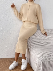 Détail d'un élégant ensemble deux pièces en tricot beige montrant le pull et la texture douce