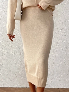 Detail view of beige knit midi skirt and long sleeve top with textured fabric finish