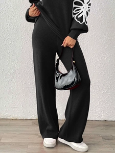 Women's black knit two-piece set with floral applique top and high waist wide leg pants