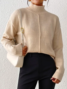 Detail of a beige turtleneck knit sweater with vertical seam and ribbed cuffs for women