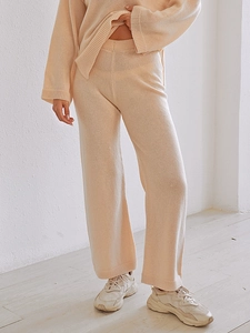 Detail of high-waisted wide leg knit trousers and long sleeve sweater in beige set
