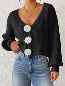Macro shot of white camellia floral buttons on a black knit cardigan sweater
