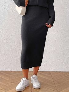 Detail view of the ribbed hem on this black knitted midi skirt with smooth plain knit texture