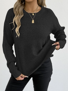 Close-up detail of black crew neck knit sweater featuring textured rib pattern and loose fit