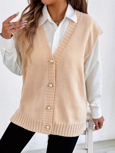 Détail des boutons en perles sur le gilet en tricot beige abricot avec col en V élégant