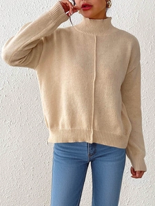 Close-up of beige mock neck knit sweater featuring a vertical center seam detail