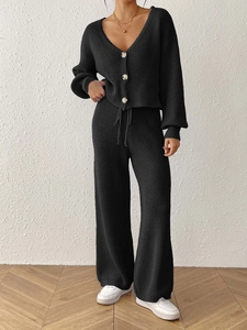 Close-up of black knit set featuring a buttoned cardigan and drawstring wide-leg pants