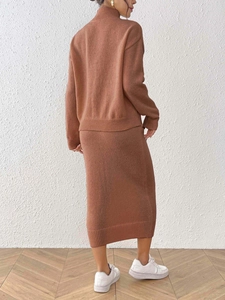 Détail d'un ensemble en tricot caramel avec pull à col montant et jupe midi côtelée
