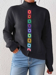 Detail of colorful embroidered floral mandalas on a black high-neck slim-fit sweater
