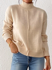 Close-up of beige mock neck sweater featuring a central vertical seam and ribbed texture