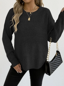 Detailed view of women's black round neck sweater featuring chunky knit texture and gold necklace