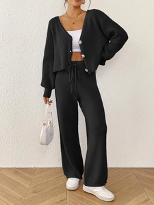 Detail of black knit cardigan with marble buttons and matching drawstring trousers