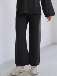Detail shot of black knitted loungewear set with ribbed texture and wide-leg trousers