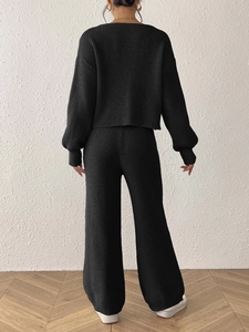 Rear view of black ribbed knit two-piece set featuring long sleeve top and wide leg pants