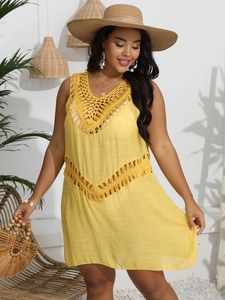 Detail of yellow beach cover-up featuring hand-crochet hollow patterns and fringe tassels